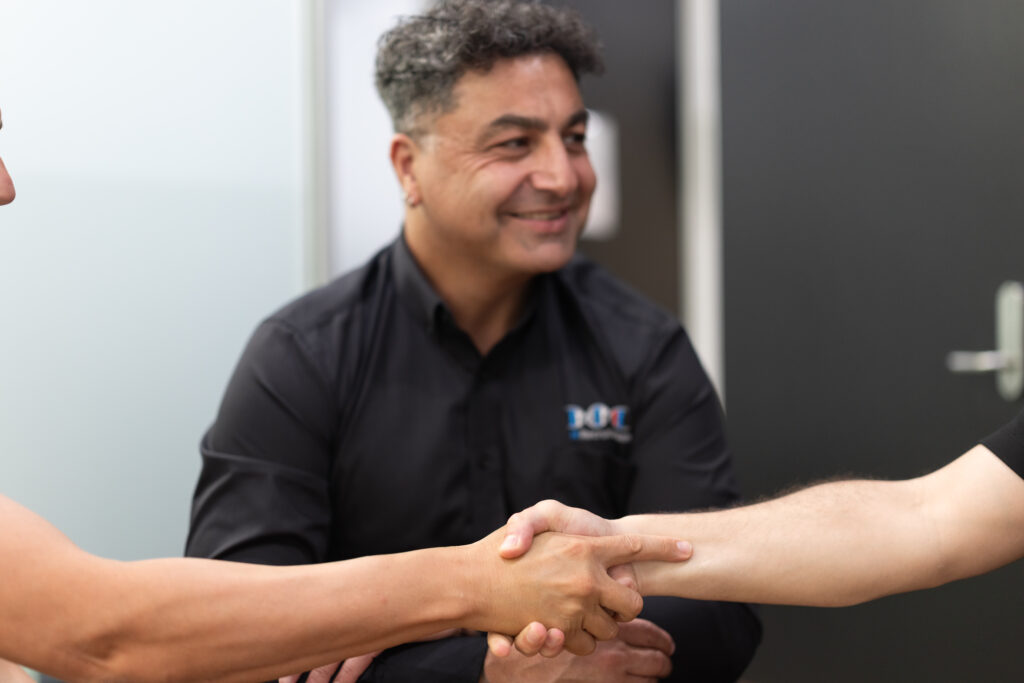 James Marroun from TLH Group engages in a handshake, symbolizing partnership and collaboration in a professional setting.