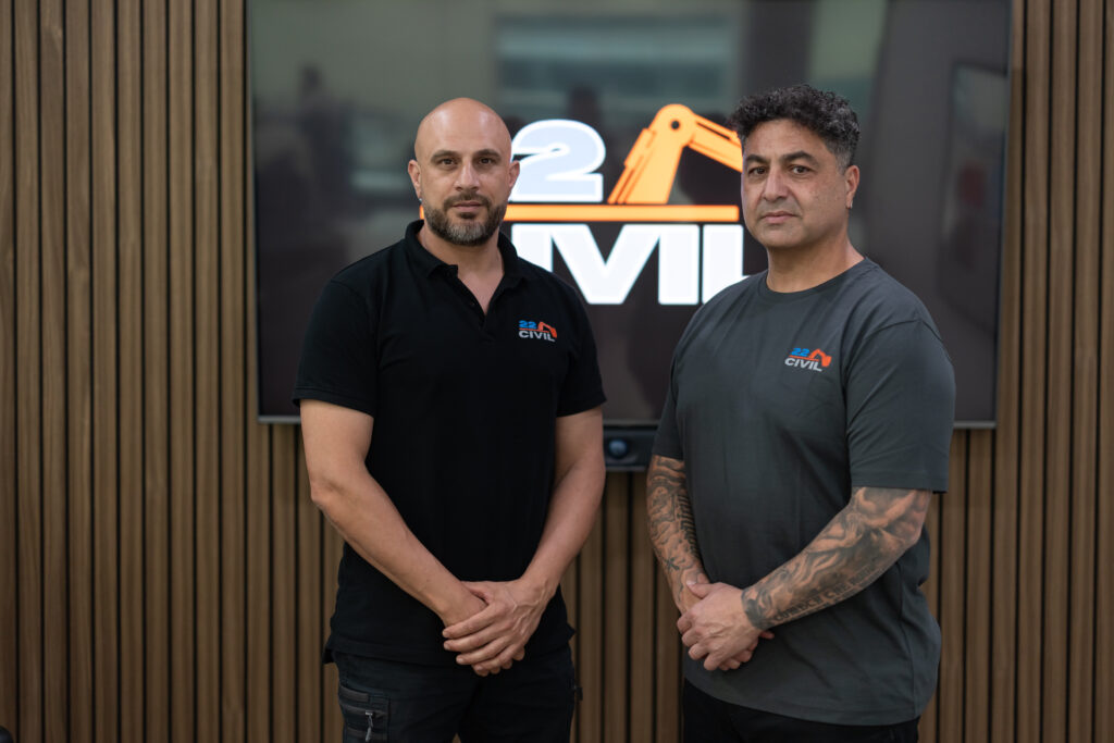 James Marroun, with Bas Khalil standing confidently in front of a logo for 22 Civil, showcasing teamwork in the construction industry.